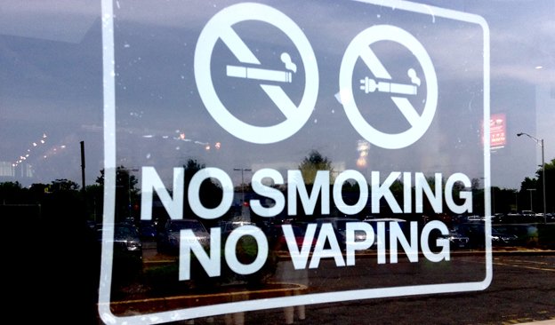 Urban street scene in Hong Kong with signage indicating no vaping, representing proposed laws to criminalize public vape use under strict tobacco control policies.