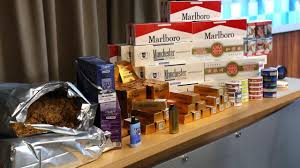Law enforcement officers inspecting seized tobacco products during an illicit tobacco crackdown in Tasmania, highlighting increased enforcement against illegal tobacco trade in Australia.