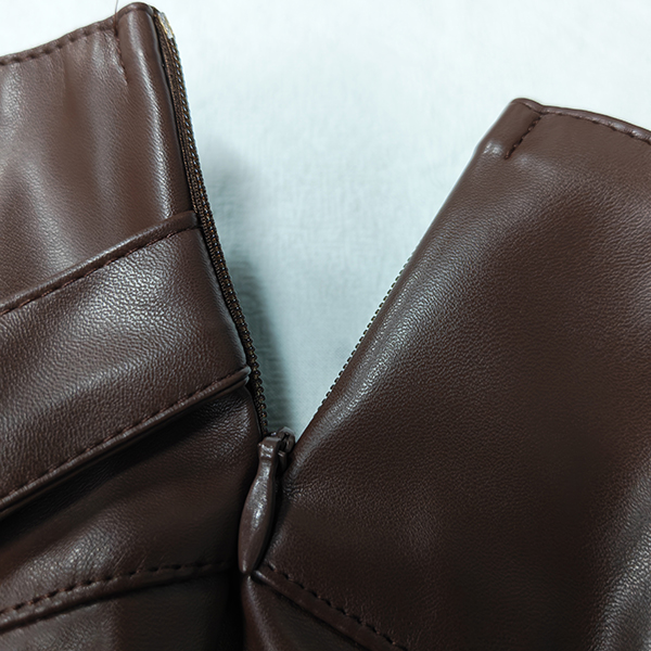 PU-LEDEREN PLISSÉ-MINIROK MET RIEMGESP