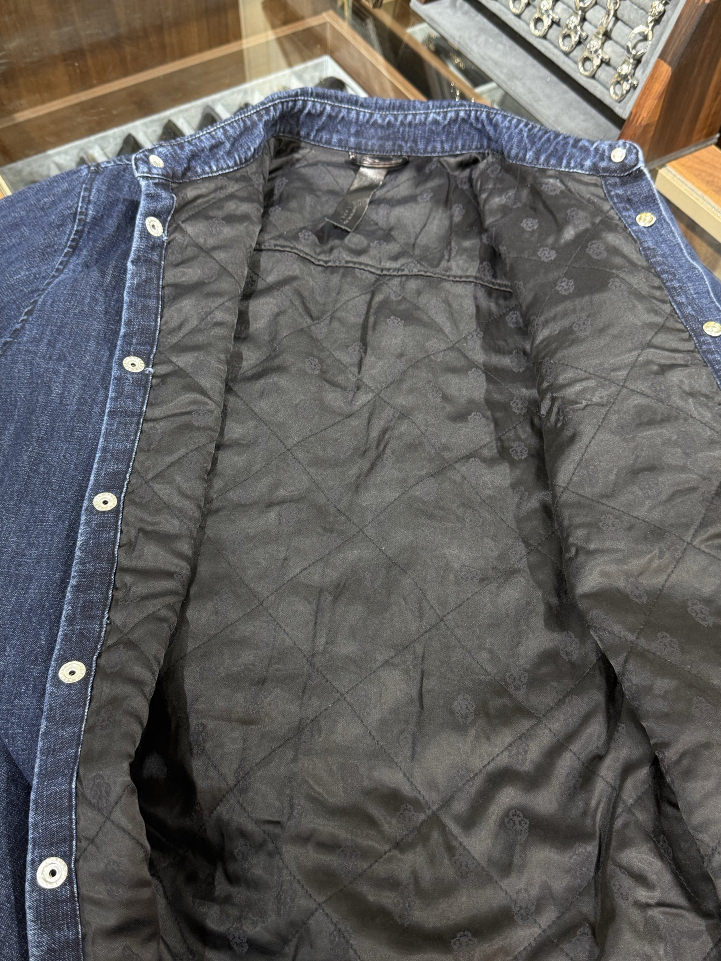 Chrome Hearts logo on the arm with Sanskrit lettering; large silver scroll and cross design on the chest; blue denim jacket. Sizes: S, M, L.