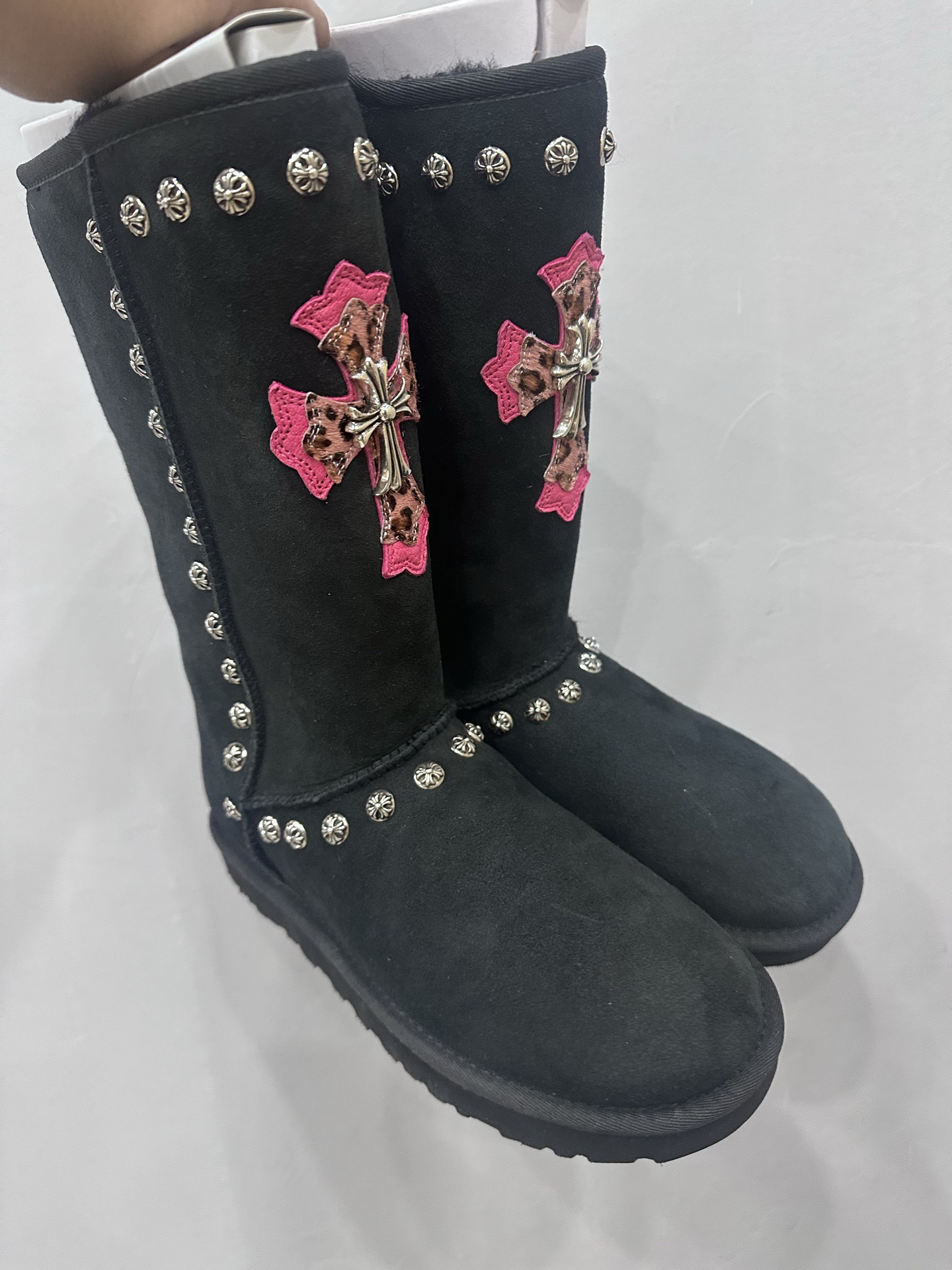 CH x UGG Classic black high-top suede and fur leather heavy-duty riveted snow boots.