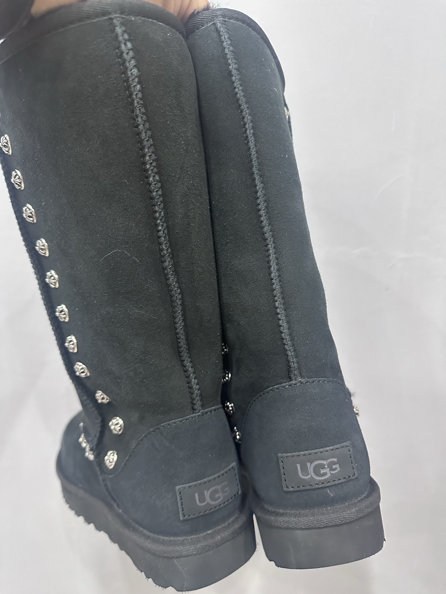CH x UGG Classic black high-top suede and fur leather heavy-duty riveted snow boots.