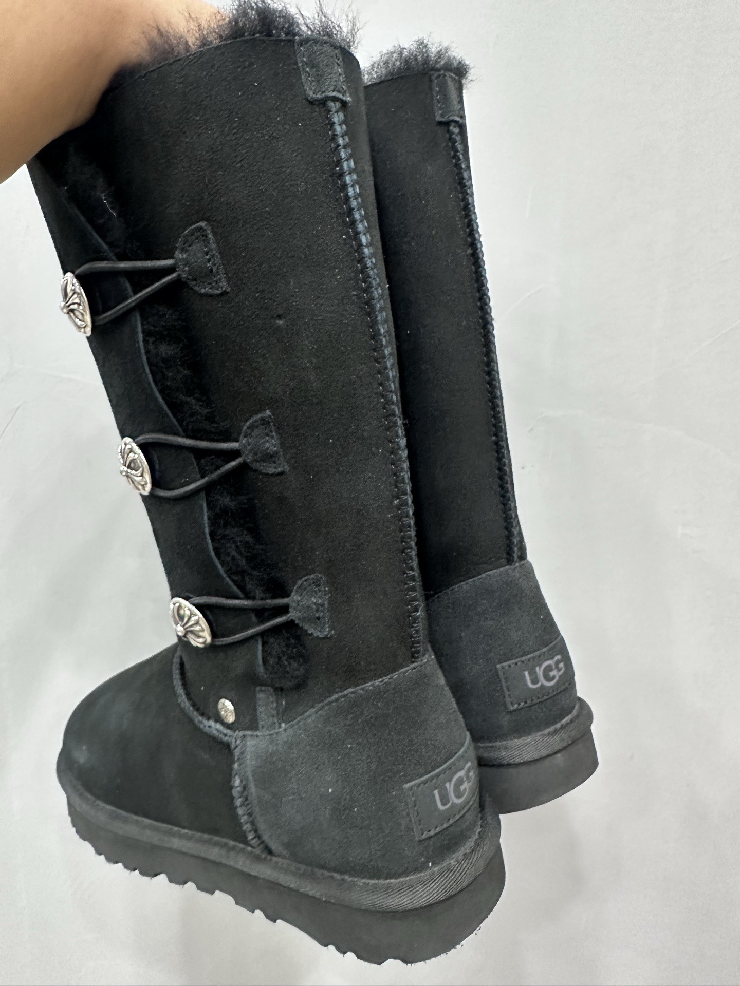 CH x UGG fur-coated black high-top side-button snow boots.