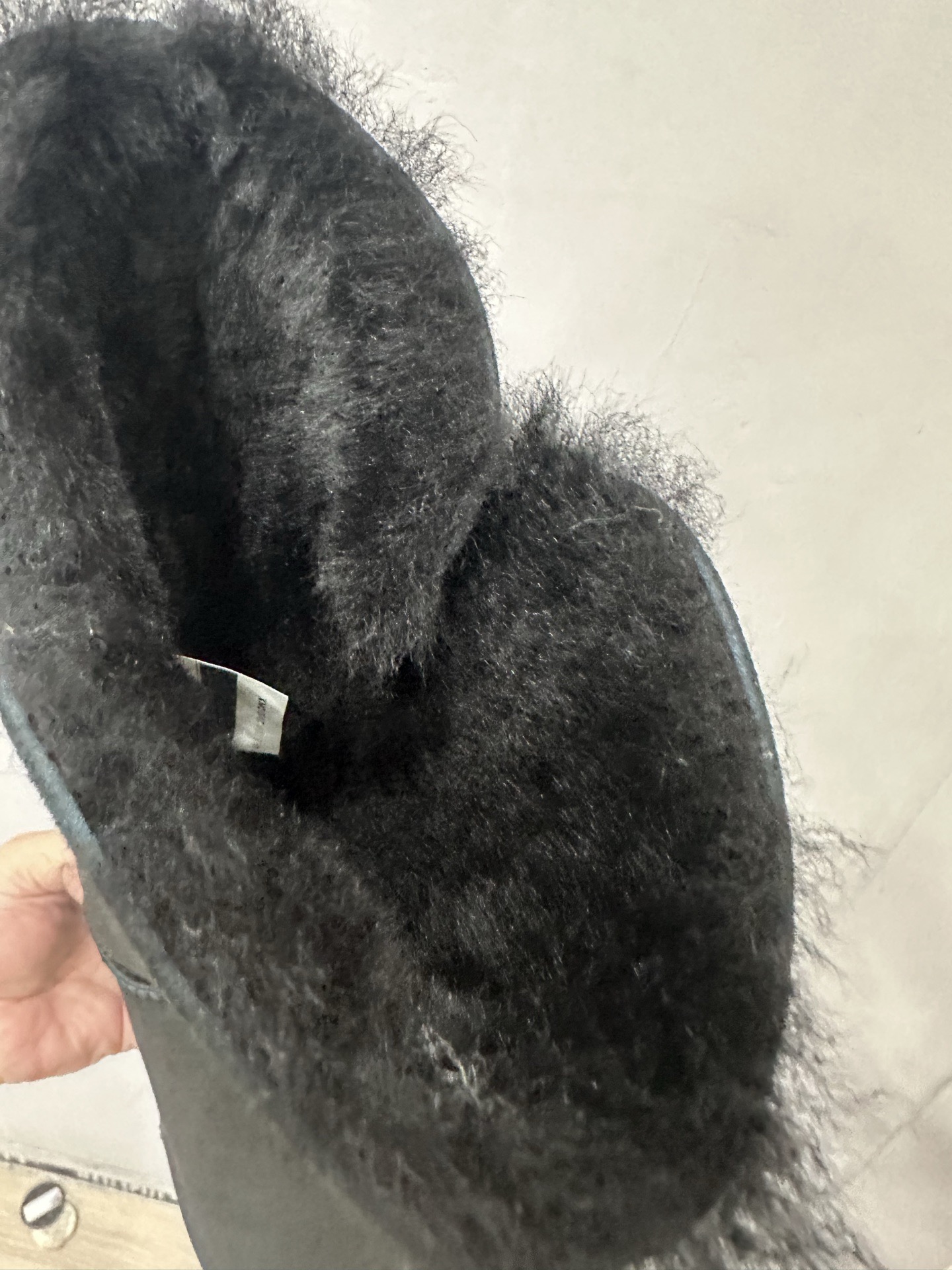 CH x UGG fur-coated black high-top side-button snow boots.