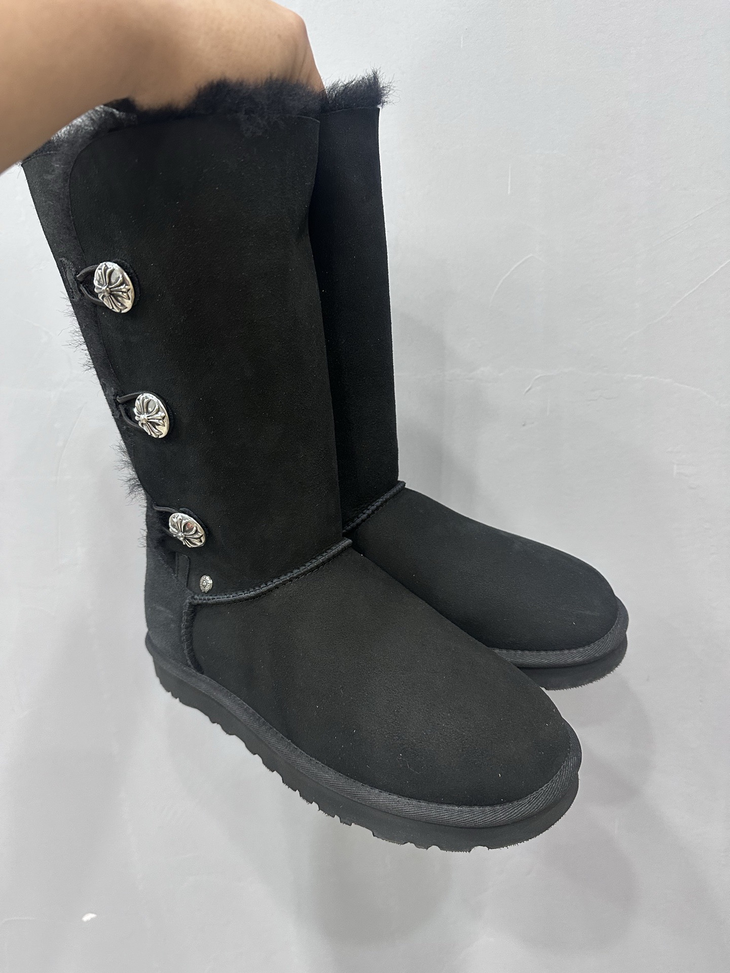 CH x UGG fur-coated black high-top side-button snow boots.