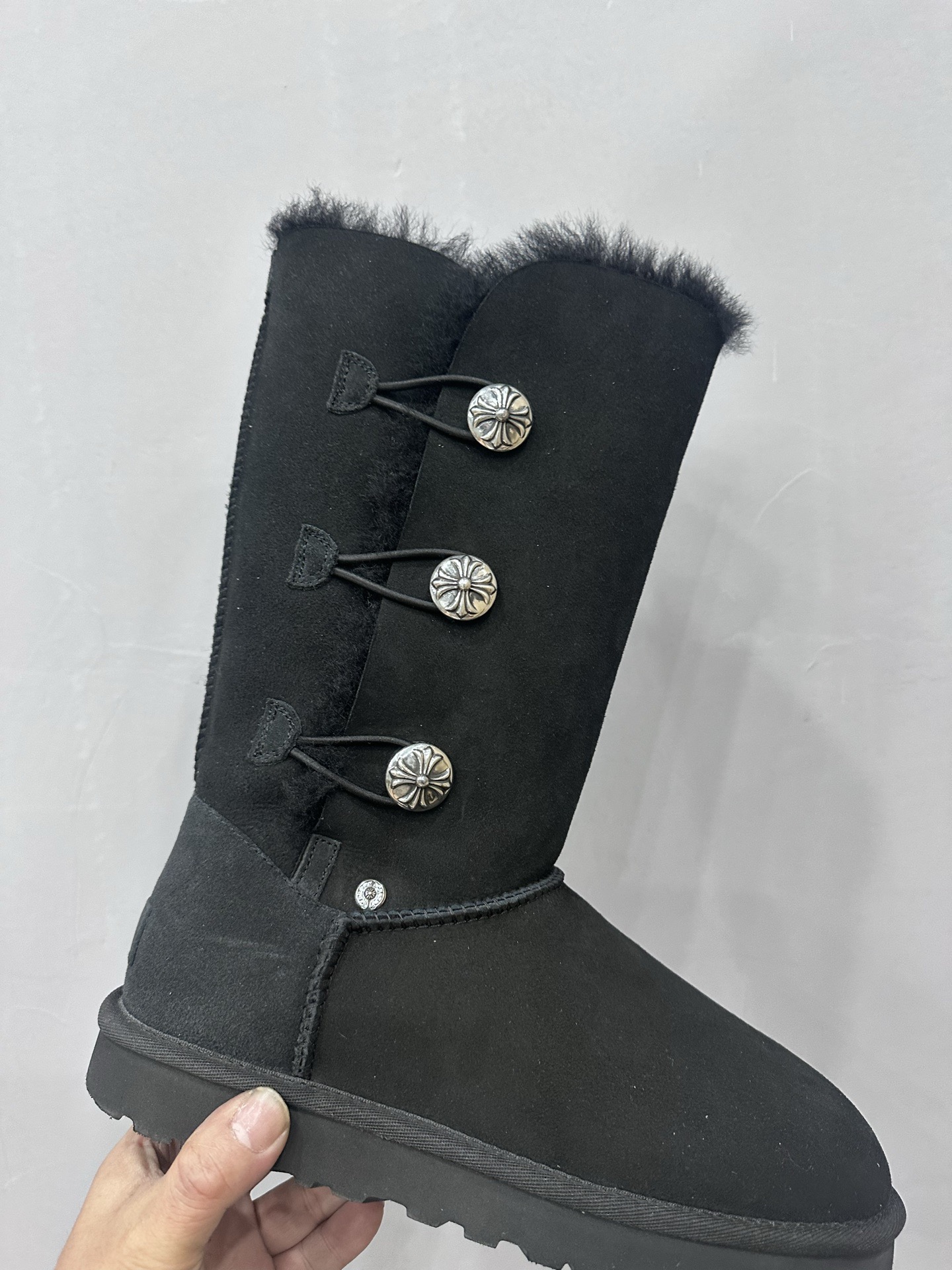CH x UGG fur-coated black high-top side-button snow boots.